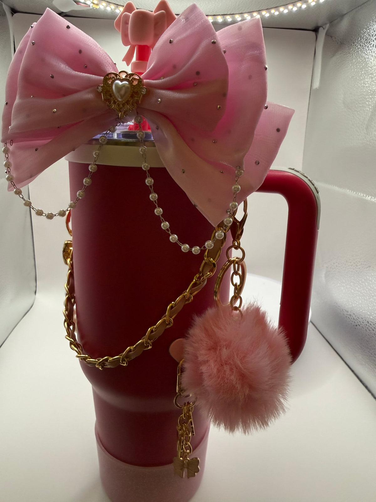 Deep pink handled tumbler with oversized pink bow, pearl-style beads, gold-tone chains and pink pom-pom charm