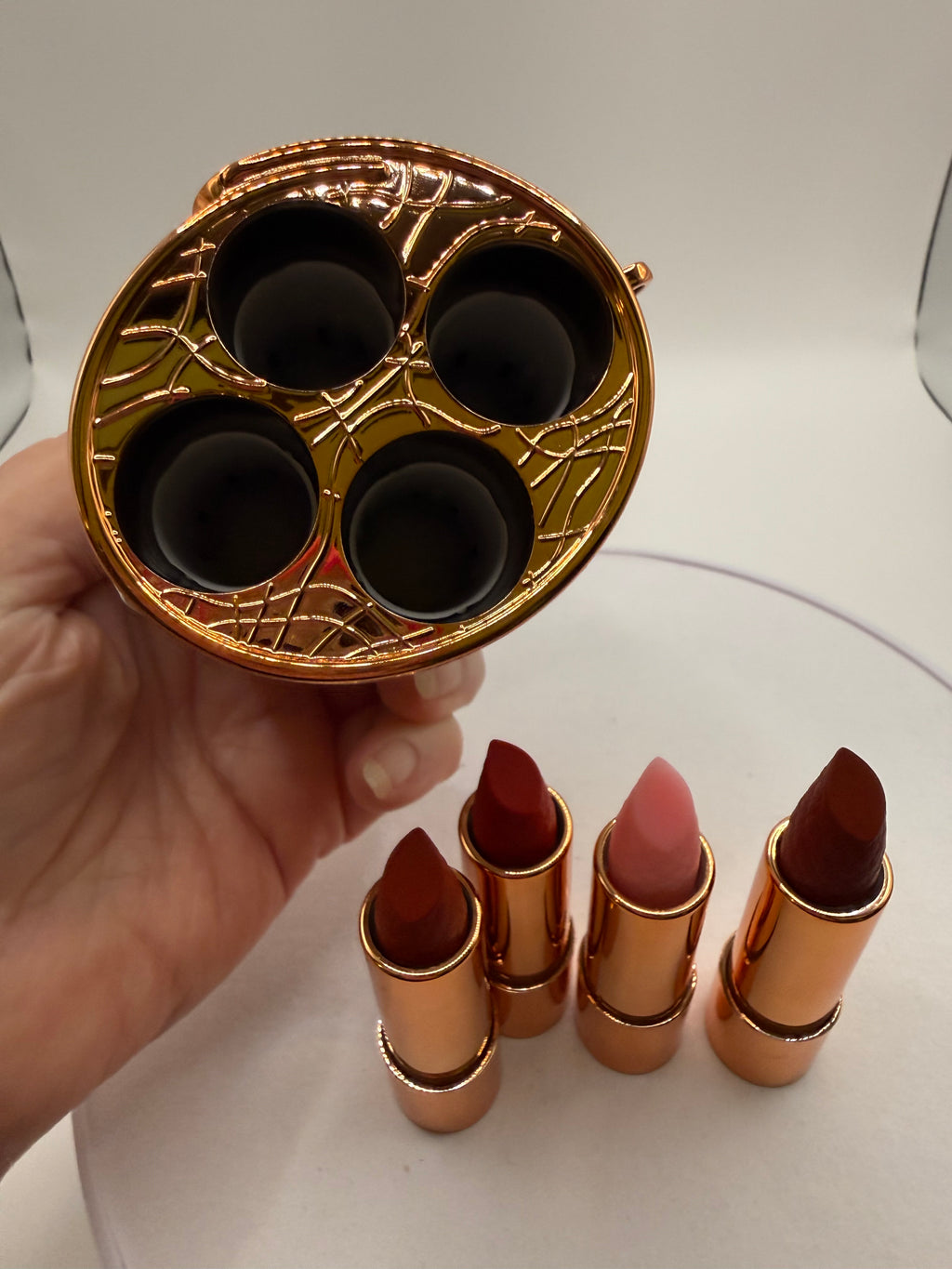 Four lipsticks beside the case base showing four storage slots